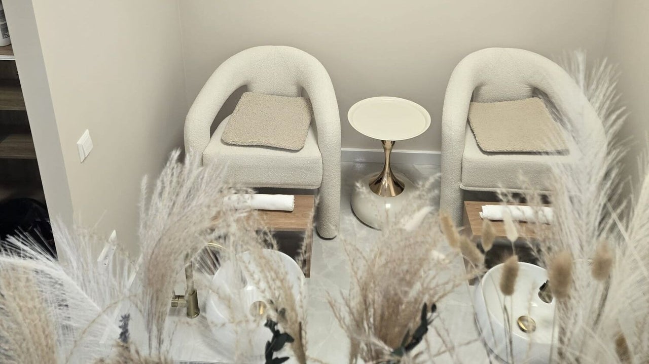 De pedicurehoek met twee crèmekleurige stoelen en pampasgras